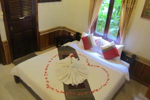 two beds with a bride decoration on them at Golden Lotus Place in Luang Prabang