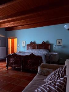 a bedroom with a large bed and a couch at B&B il Baciass in Pinerolo