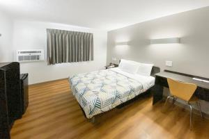 a bedroom with a bed and a desk and a piano at The Reserve Inn in Salisbury