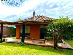 a small house with a bench in the yard at Casa del Parque in Talca