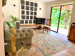a living room with a couch and a television at Casa del Parque in Talca