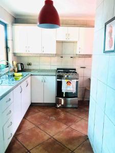 a kitchen with a stove and a red light at Casa del Parque in Talca +7 photos