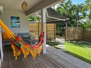 a hammock on a deck with a house at O Ti Boneur in Sainte-Rose