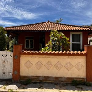 a red house with a fence in front of it at Casa in Baia Formosa-Bùzios in Búzios