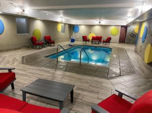 a pool in a room with chairs and a table at Best Western Plus Sandusky Hotel & Suites in Sandusky