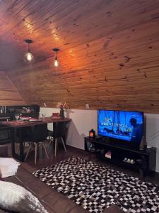 a living room with a flat screen tv and a table at Cabanas Paxixi - Mirante in Camisão