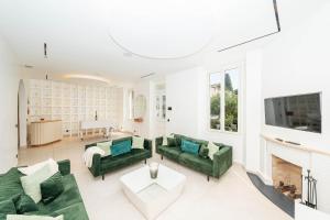 a living room with green couches and a fireplace at Villa Rosoliel in Cannes