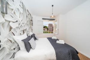 a bedroom with a white bed with a tree mural at Villa Rosoliel in Cannes +60 photos