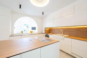 a kitchen with white cabinets and a wooden counter top at Villa Rosoliel in Cannes