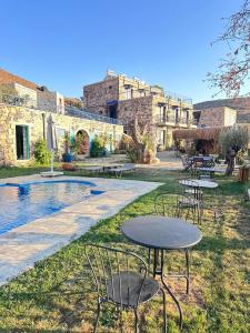 a patio with tables and chairs next to a pool at FİNTOZ BUTİKA New in Karaburun