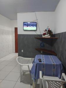 a room with a table and chairs and a tv on the wall at Casa para temporada in Belém +30 photos