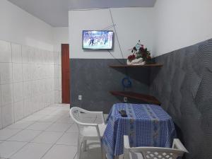 a room with a table and two chairs and a tv at Casa para temporada in Belém
