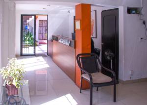 a living room with a chair and a counter at Hotel Posada del Angel in Mérida +45 photos