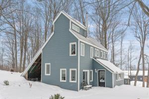 a blue house with snow on the ground at Strathmere Country Retreat in Ottawa