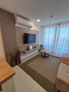 a living room with a couch and a flat screen tv at LUXER VIVO Encarnacion in Encarnación