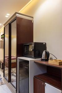 a microwave oven sitting on top of a counter at Hana Grand Hotel in Madinat Al Ashir min Ramadan
