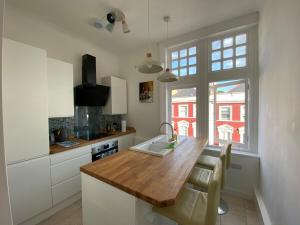 a kitchen with a wooden counter top and a window at High Street 3BR city views near beach - Groups, Families, Contractors in Bournemouth