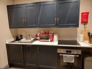 a kitchen with black cabinets and a red microwave at The Snook-Free Parking-Near Pentland Hills in Loanhead +13 photos