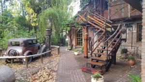 an old car parked next to a building with a staircase at Na Petko suite in Gaiman