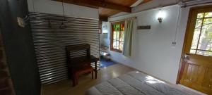 a bedroom with a bed and a chair and a window at Na Petko suite in Gaiman +2 photos