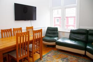 a living room with a table and chairs and a couch at High Street 3BR city views near beach - Groups, Families, Contractors in Bournemouth