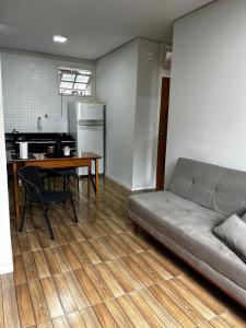 a living room with a couch and a table at Apartamento 1 quarto, sala e cozinha próximo ao Aeroporto in Vitória