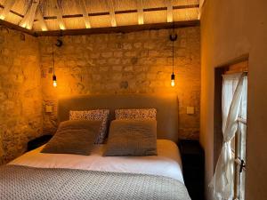 a bedroom with a bed with two pillows at Le Manoir du Perroy in Saint-Wandrille-Rançon