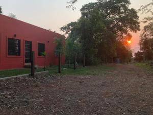 a red building with the sunset in the background at Casa roja in Eldorado +4 photos