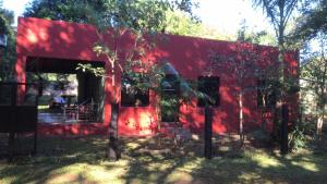a red building with a tree in front of it at Casa roja in Eldorado