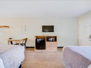 a room with two beds and a table and a tv at The Atwood Hotel San Diego - SeaWorld/Zoo in San Diego +40 photos