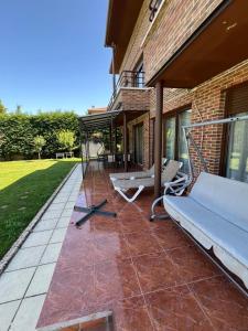 a patio with a couch and chairs on a house at VILLA TOMILLARES in Los Tomillares