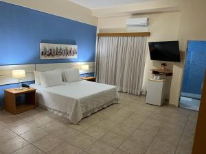 a bedroom with a bed and a flat screen tv at Pousada Barlavento in Iriri +24 photos