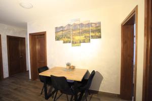a dining room with a wooden table and chairs at Pokoje gościnne u Sołtysów in Jurgów