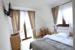 a bedroom with a bed and some windows at Pokoje gościnne u Sołtysów in Jurgów