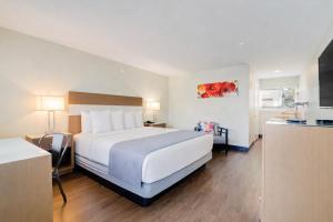 a hotel room with a large bed and a kitchen at The Atwood Hotel San Diego - SeaWorld/Zoo in San Diego