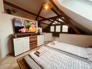 a bedroom with a bed and a flat screen tv at Groasmückle Apartment in Tauberbischofsheim