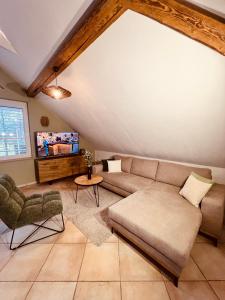 a living room with a couch and a tv at Groasmückle Apartment in Tauberbischofsheim