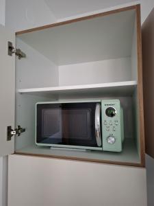 a microwave oven in a cabinet in a kitchen at Cosy central apartment in Litija