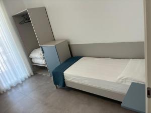 a small bedroom with a bed and a shelf at Matilde Apartments Caorle in Caorle