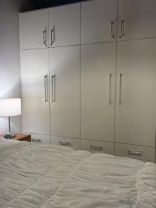 a bedroom with white cabinets and a bed at Mini Casa-Aconchego e Fitness in Pirenópolis