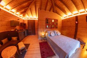 a bedroom with a bed in a wooden room at Pensión Cabañas Bosque Máxico de Bonxe in Outeiro de Rei