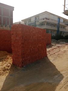 a stack of red bricks in front of a building at التطبيقيين راس البر in Ras El Bar