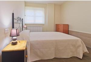 a bedroom with a bed and a table with a lamp at Apartamentos turísticos Sardon in Sardón de los Frailes