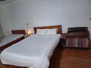 a bedroom with two beds and a chair at Beautiful Homestay Sapa in Sapa