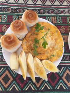 a plate of food with an omelet and pancakes and bananas at Beautiful Homestay Sapa in Sapa