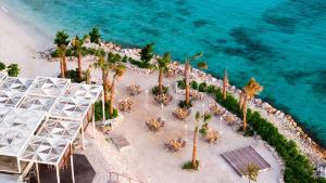 an aerial view of a beach with palm trees and tables at Curaçao Marriott Beach Resort in Willemstad
