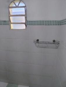 a bathroom with a window and a white tiled shower at Edícula Planalto in Manaus +11 photos
