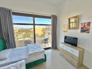 a bedroom with a bed and a large window at View Pool Apartment, Two Rooms in El Gouna