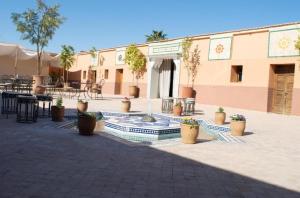 a courtyard with a fountain and potted plants in front of a building at Villa Dar Saada in Marrakesh