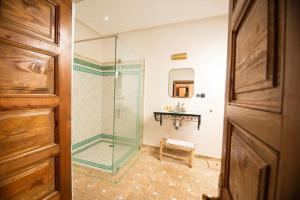 a bathroom with a glass shower with a bench at Villa Dar Saada in Marrakesh +43 photos